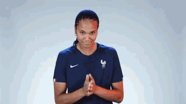 a woman wearing a blue nike shirt with a rooster on the front