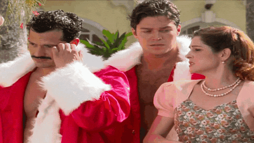 a man in a santa suit talks on a cell phone next to a woman