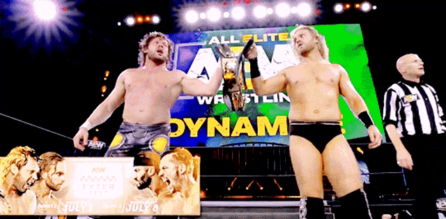 two wrestlers in front of a sign that says dynamite