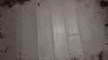 a black and white photo of a bloody room with a door .