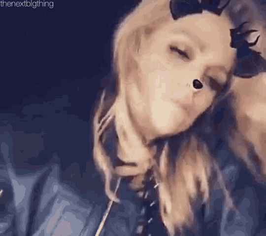 a woman wearing a cat mask is making a face with her eyes closed .