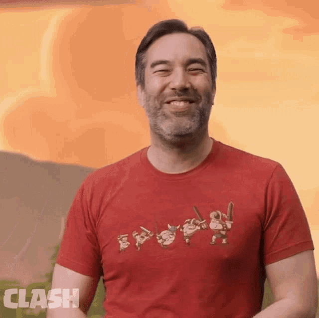 a man wearing a red clash t-shirt smiles