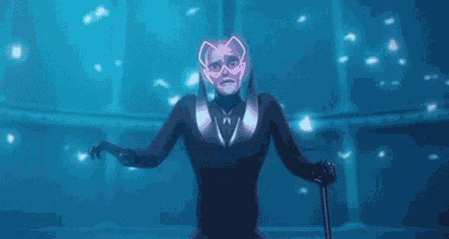 a man in a suit and mask is holding a cane and standing in a dark room .