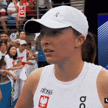 a woman wearing a white hat and a white tank top with the word nfasis on it