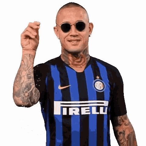 a man wearing sunglasses and a blue and black striped shirt with the word irelli on it .