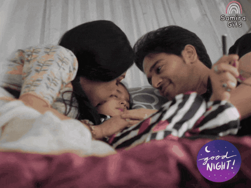 a man and a woman laying on a bed with a good night sticker
