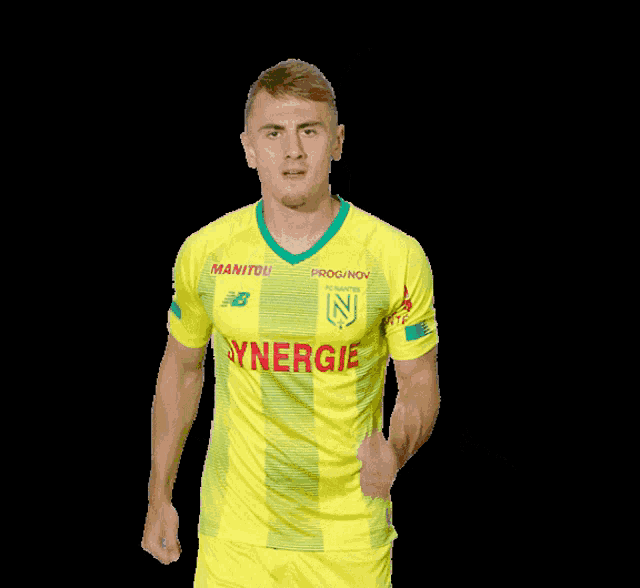 a man wearing a yellow and green jersey that says synergi on it