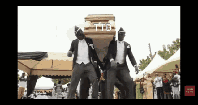 two men in tuxedos are carrying a coffin with the word ttb on it