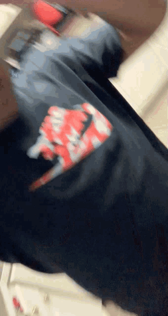 a person is wearing a black shirt with a red and white nike logo on it