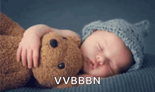a baby is sleeping next to a teddy bear and the words vvbbn are visible