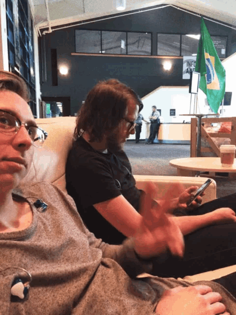two people are sitting in front of a sign that says " information "