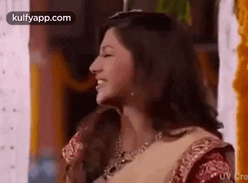 a close up of a woman in a saree smiling .