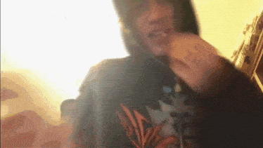 a blurry picture of a person wearing a hoodie with a leaf design