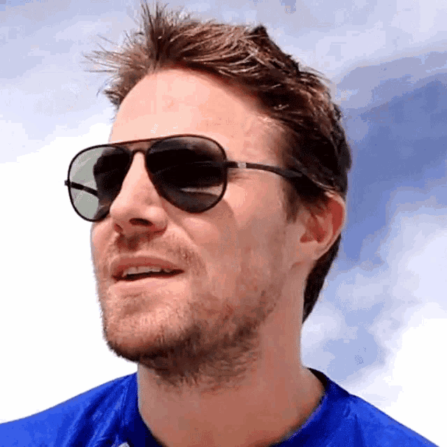 a man wearing sunglasses and a blue shirt