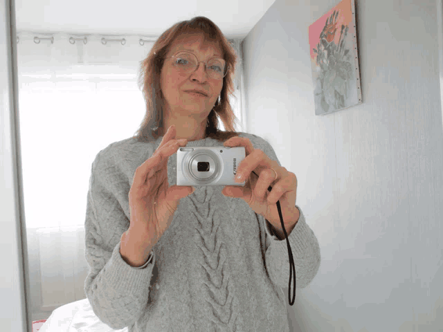 a woman taking a picture of herself with a nikon camera