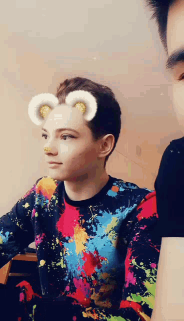 a boy wearing a colorful sweater with a sheep face mask