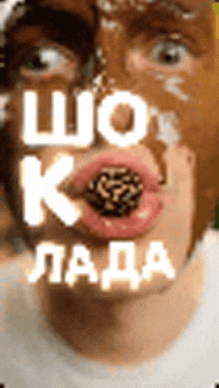 a man with chocolate on his face has a cookie in his mouth