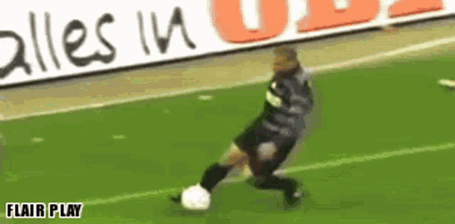 a soccer player kicks a soccer ball in front of a banner that says alles in u2