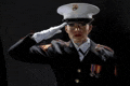 a woman in a military uniform is saluting .