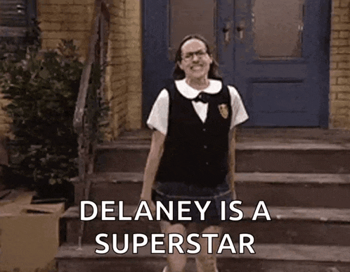 a woman in a school uniform is standing on a set of stairs with the words `` delaney is a superstar '' .