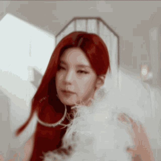 a woman with red hair wearing a white feather boa