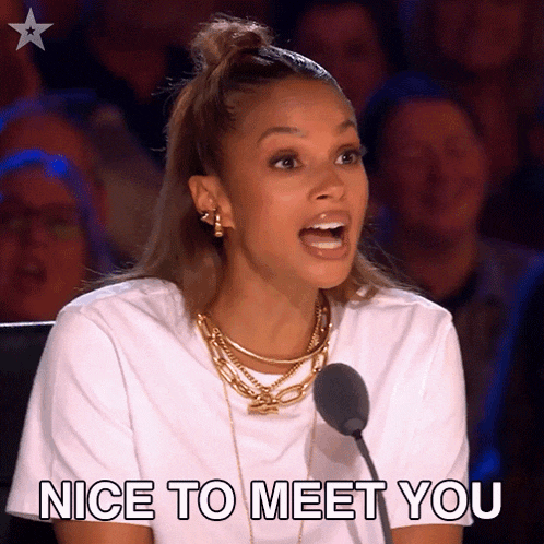 a woman sitting in front of a microphone with the words nice to meet you behind her