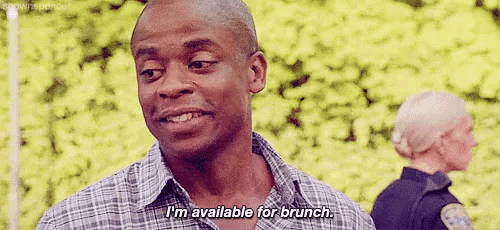 a man in a plaid shirt is talking to a police officer and saying `` i 'm available for brunch . ''
