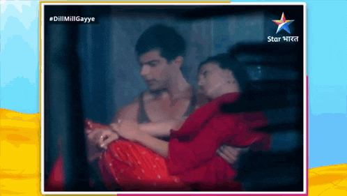 a man is carrying a woman in his arms with a star india logo behind them
