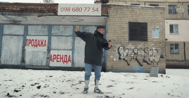 a man stands in front of a building with a sign that says 098680 77 54