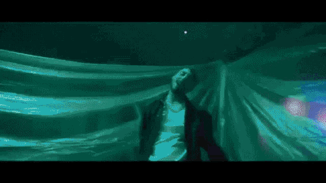 a man is standing in a dark room with green lights