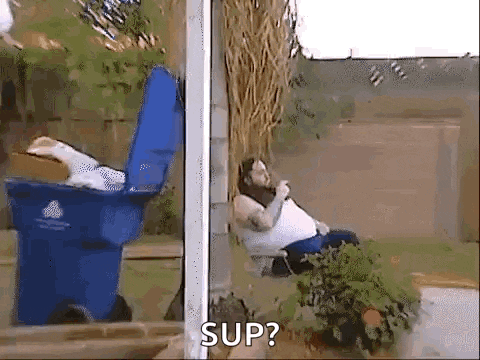 a man is sitting on a porch next to a blue trash can with the word sup written on it .
