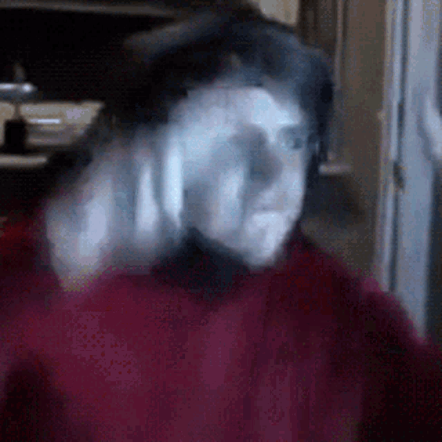 a blurry picture of a person 's face with a red shirt on