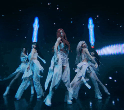 a group of young women are dancing in front of a large screen