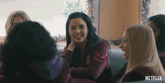 a group of women sitting around a table with a netflix logo on the bottom