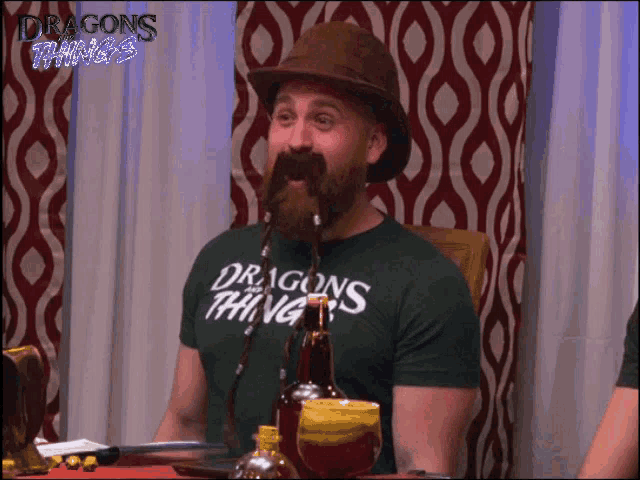 a man with a beard is wearing a dragons thing t-shirt