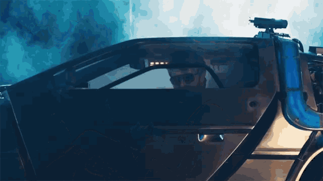 a man wearing sunglasses sits in a futuristic vehicle
