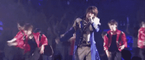 a man is singing into a microphone on stage .
