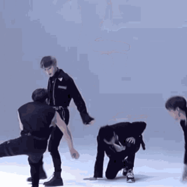 a group of young men are dancing on a white floor