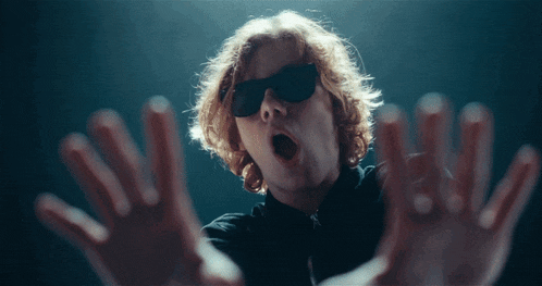 a man wearing sunglasses has his mouth open