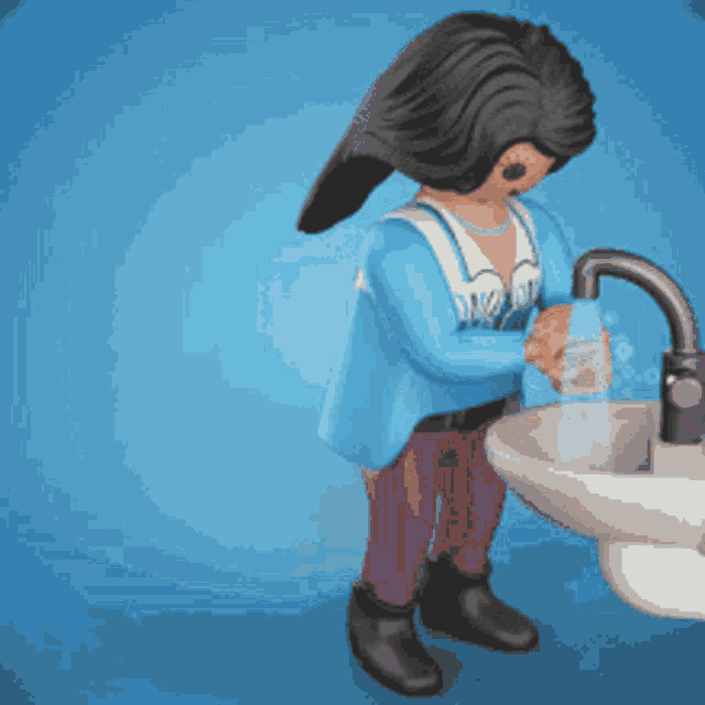 a toy figure is washing her hands in a sink