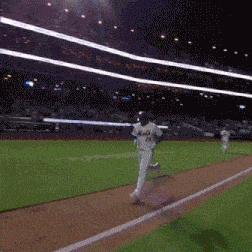 a baseball player wearing a mets jersey is running across the field