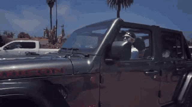 a man wearing sunglasses and a bandana is driving a car