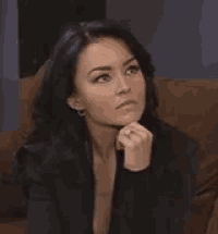 a woman with a ring on her finger is sitting on a couch .