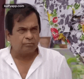 a man wearing a white shirt is making a funny face .