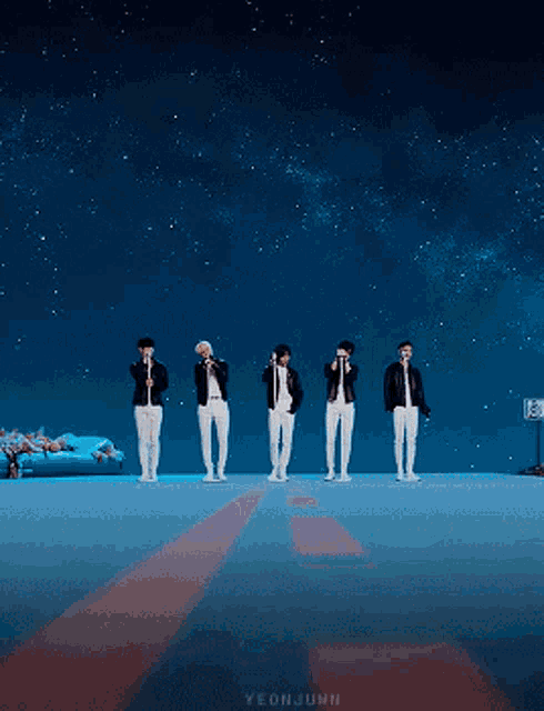 a group of men are standing in front of a starry sky with the name yeonjunh on the bottom right