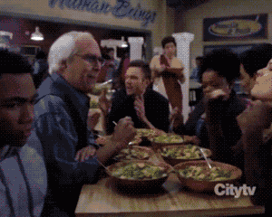 a group of people are sitting at a table with bowls of food in front of a sign that says citytv