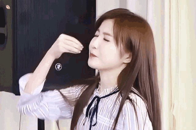 a woman with long brown hair is standing in front of a speaker that says yamaha on it