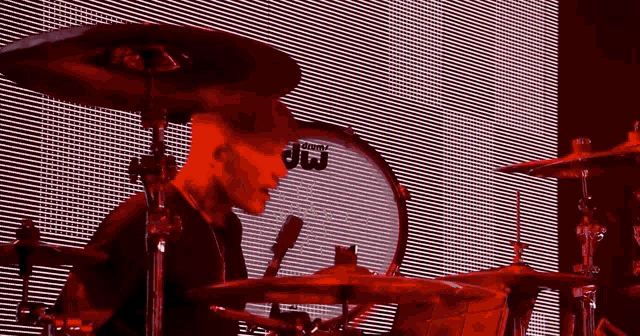 a man playing drums in front of a dw drum set