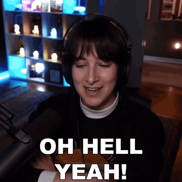 a woman wearing headphones is saying oh hell yeah