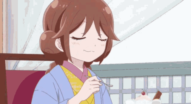 a girl in a kimono is eating something with a fork